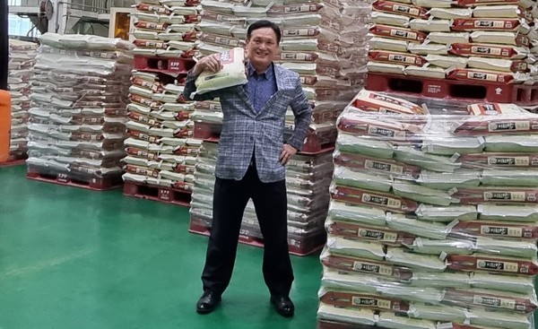 지인구 대월농협조합장이 지역 쌀 소비 촉진을 위해 자비를 들여 구매한 쌀 앞에서 사진을 찍고 있다.  