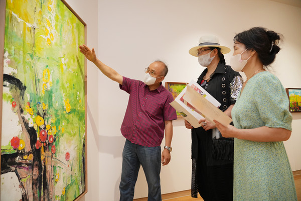 강해중 작가(사진 왼쪽 첫번째)가 BNK경남은행갤러리를 찾은 지역민들에게 작품을 안내하고 있다. 사진/경남은행