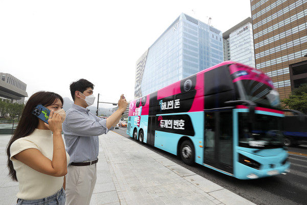 사진은 KT 고객이 ‘듀얼번호 버스’를 촬영해 SNS 올리는 인증샷 이벤트에 참여하는 모습. 사진/kt