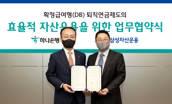 하나은행은 지난 1일 오후 을지로 하나은행 본점에서 삼성자산운용과 확정급여형(DB) 퇴직연금제도의 효율적 자산운용을 위한 전략적 업무협약(MOU)를 체결했다. 이날 협약식에 참석한 김기석 하나은행 자산관리그룹 부행장(사진 왼쪽)이 서봉균 삼성자산운용 대표(사진 오른쪽)와 함께 업무협약서를 들고 기념촬영을 하고 있다. 사진/하나은행