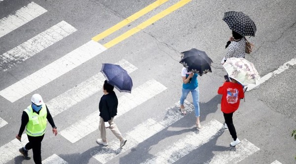 광주 서구 치평동에서 시민들이 햇빛을 가리는 양산을 쓰고 걷고 있다. 사진/연합뉴스