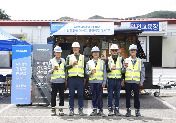 경남 합천군에 위치한 함양-창녕간 고속도로 건설현장에서 두산에너빌리티와 협력사 직원들이 커피차 앞에서 기념촬영을 하고 있다.