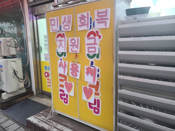 경기도의 한 무인 아이스크림 상점 앞에 ‘민생회복 소비쿠폰’ 사용 가능을 알리는 전단지가 붙어있다. 사진/김혜준 기자