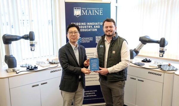 두산로보틱스 김현수 상무(왼쪽)가 메인대학교 첨단제조센터 브래들리 덴홀름 부소장과 기념사진을 촬영하고 있다.