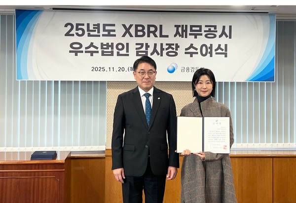 지난 20일 진행된 ‘XBRL 재무공시 우수법인 감사장 수여식’에서 박아람 네오위즈 공시 담당(오른쪽)이 이승우 금융감독원 부원장보와 기념촬영을 하고 있다. 