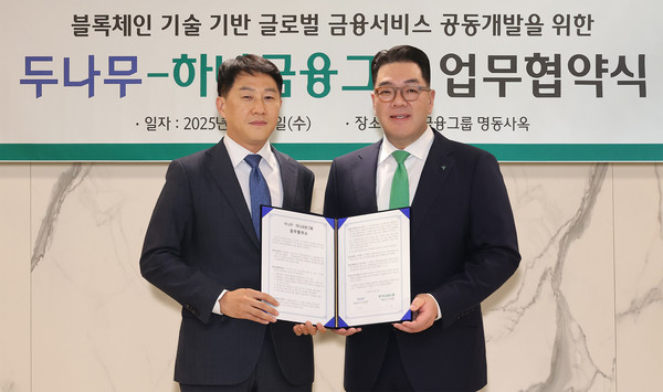 협약식에 참석한 이은형 하나금융그룹 부회장(사진 오른쪽)이 오경석 두나무 대표이사(사진 왼쪽)와 함께 협약서를 들고 기념촬영을 하고 있다. 사진/하나금융그룹